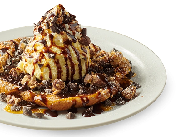 A plate sized, warm & gooey cookie topped with ice cream
