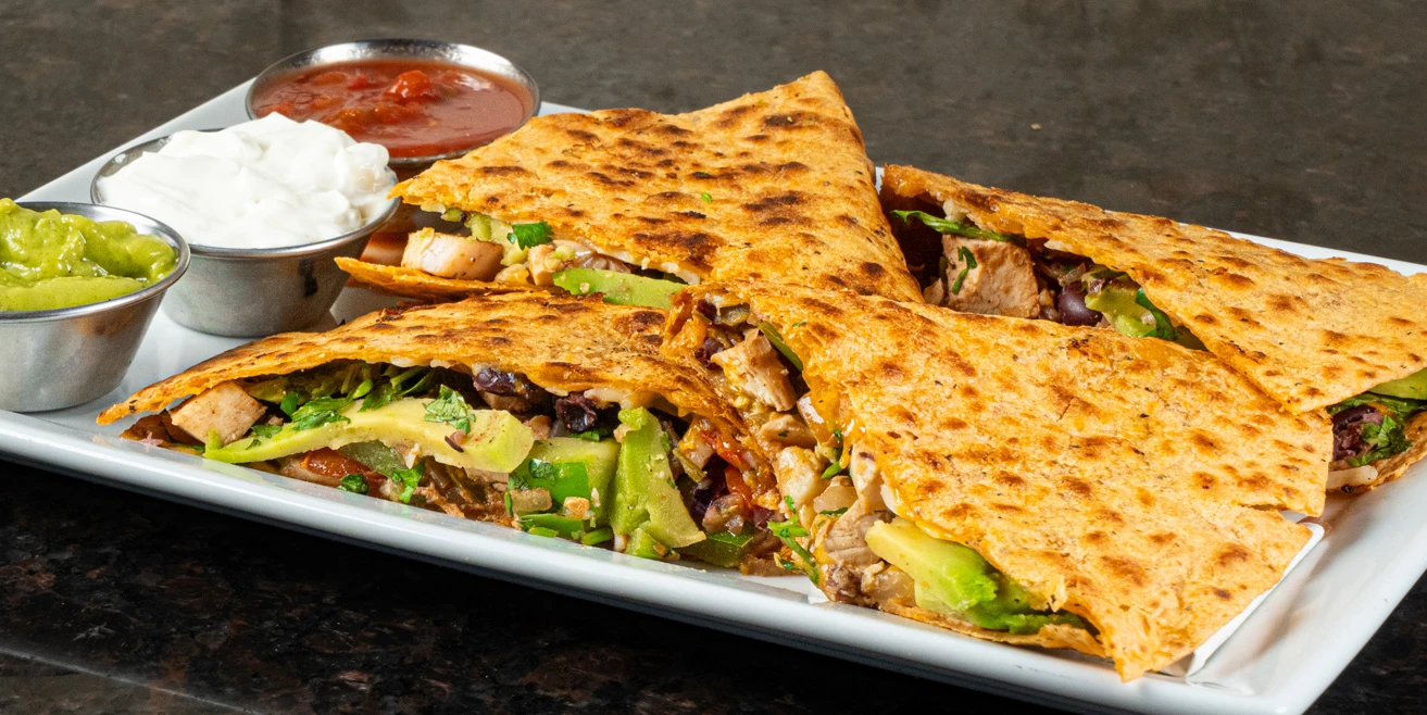 Zesty chicken quesadilla with avocado and pico de gallo, a casual lunch and dinner appetizer at Symposium Cafe