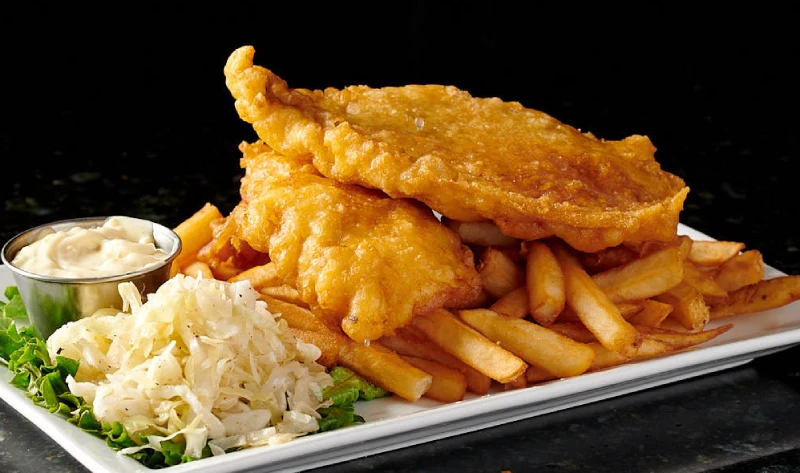 Golden battered haddock fish and chips with crispy fries and coleslaw, great for lunch or dinner at Symposium Cafe