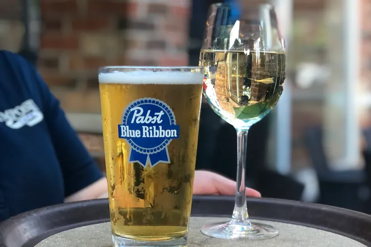 Happy hour beer and wine specials at Symposium Cafe: a pint of PBR draught and a glass of Dragani white wine on the patio