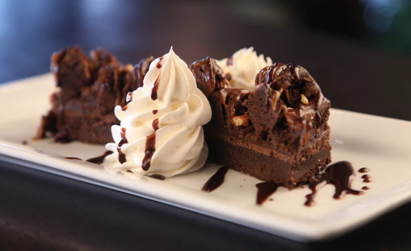 Rockslide brownie with caramel, toasted pecans and chocolate ganache, a decadent dessert at Symposium Cafe