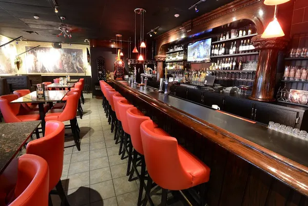 Guelph bar and lounge interior with red leather seating, custom woodwork and comfortable bar stools.