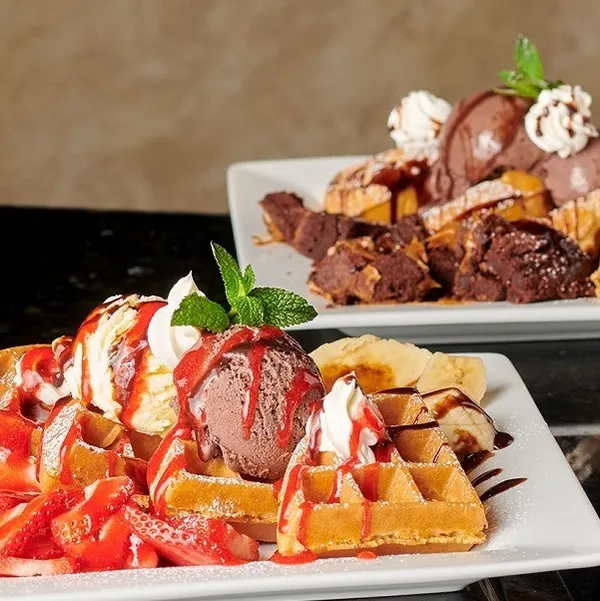 Oshawa dessert café serving a golden Belgian waffle topped with creamy ice cream and rich dessert sauce.