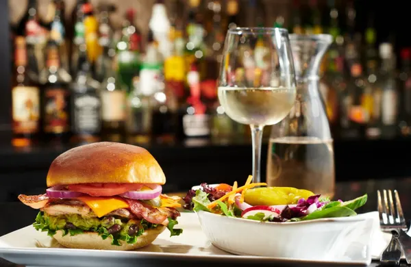 Symposium Cafe gourmet lunch with chicken bacon club sandwich, fresh salad and chilled wine.