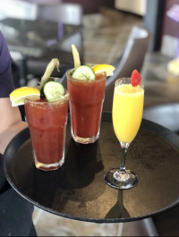 A flight of popular brunch cocktails in Ajax, featuring two loaded Caesars and a fresh Mimosa during our $6.95 weekend d