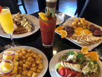 A full table spread for the best brunch in Ajax, featuring Steak and Eggs, signature Eggs Benedict, thick-cut French Toa