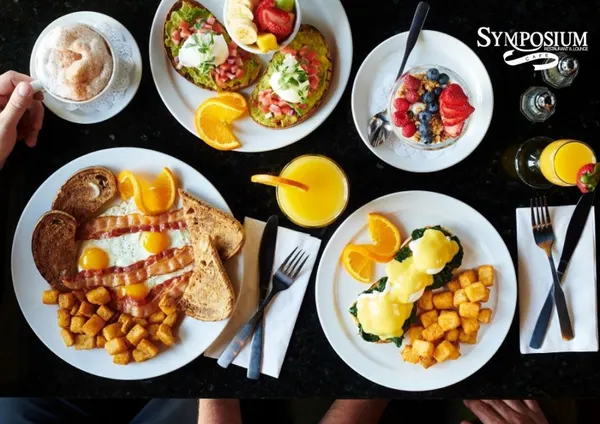 Weekend brunch in Bolton with Eggs Benedict, fresh fruit and a bright mimosa at Symposium Cafe Restaurant.