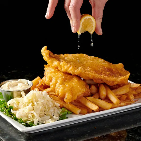 Oakville dinner spot serving golden fish and chips with fries, creamy coleslaw, tartar sauce and fresh lemon.