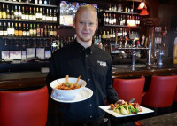 guelph restaurant waiter serving customers with beautiful bar in background symposium cafe