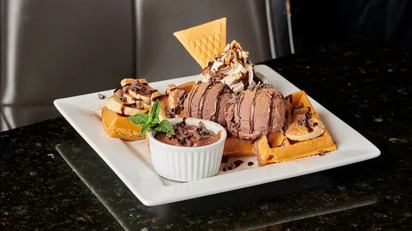Nutella banana waffle with chocolate ice cream and indulgent hazelnut drizzle at Symposium Cafe.