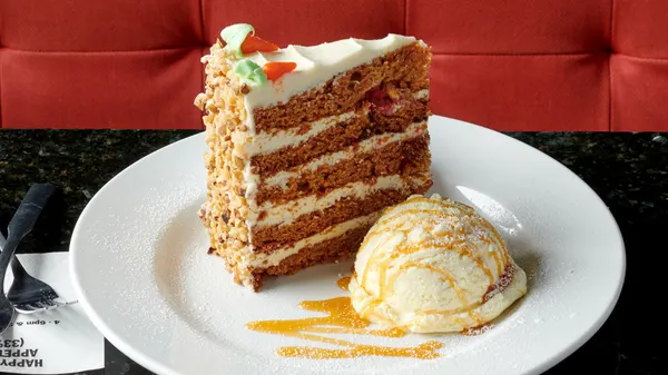 Legendary Sky-High Carrot Cake with vanilla ice cream served at Symposium Cafe Restaurants across Ontario.