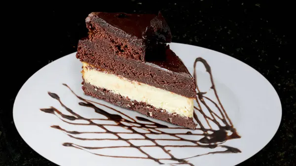 Triple Brownie Fudge Cheesecake with rich chocolate layers from the Symposium Cafe dessert menu.