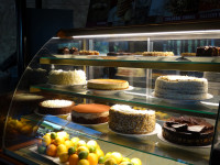 A full display fridge featuring a variety of gourmet cakes and brownies at Symposium Cafe Aurora, the best spot for dess