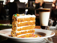 A slice of sky-high carrot cake and a warm latte at Symposium Cafe Aurora, part of our 2-for-1 Sunday dessert special ne