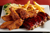 A signature dinner of fall-off-the-bone ribs and crispy wings served with golden fries at the best dinner restaurant in 