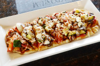 A fresh and flavorful vegetarian flatbread appetizer with Mediterranean toppings at the best dinner restaurant in Ajax n