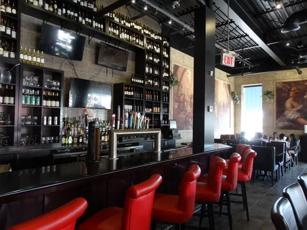 The beautiful bar and lounge area at Symposium Cafe Ajax, featuring comfortable bar seating and elegant decor