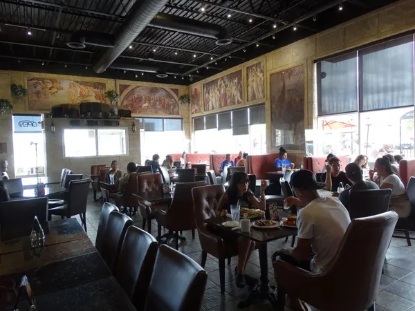 Ajax restaurant interior at Symposium Cafe with warm lighting, comfortable seating and stylish dining-room décor.