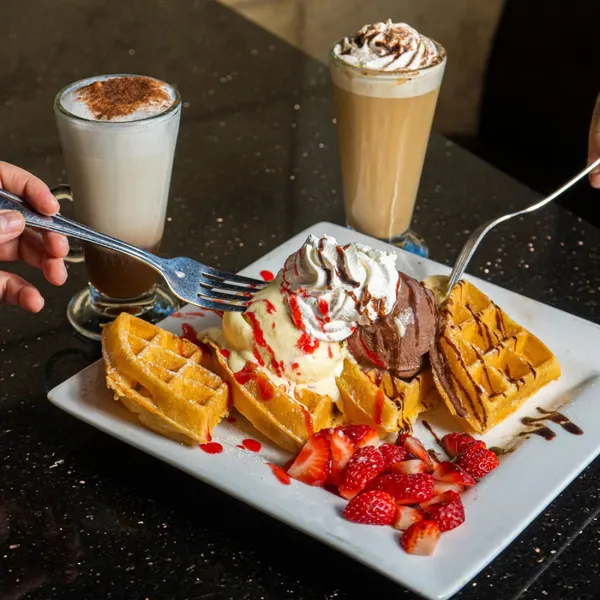 Belgian waffles with ice cream strawberries and café drinks at Symposium Cafe Oakville
