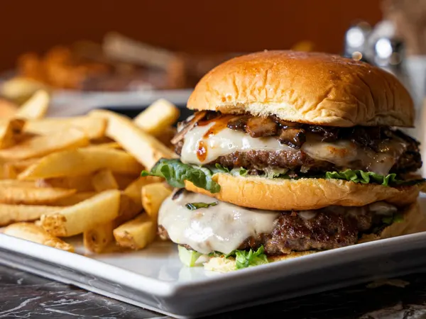 Waterloo Ontario lunch and dinner spot featuring a mushroom cheeseburger with melted cheese and crispy fries.