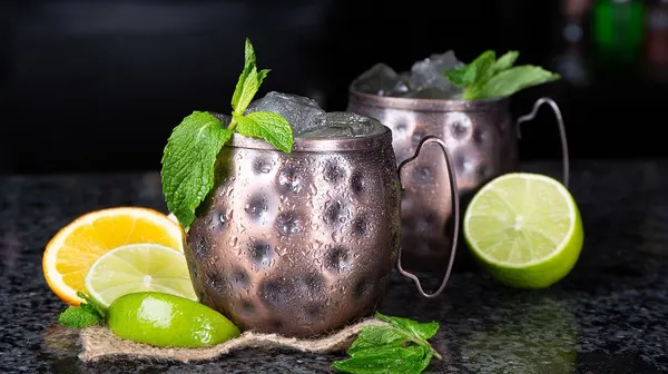 Aurora cocktail bar serving refreshing mule cocktails with bright citrus in chilled copper mugs.