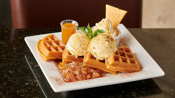 Aurora dessert café serving a hot Belgian waffle with creamy ice cream and rich caramel sauce.