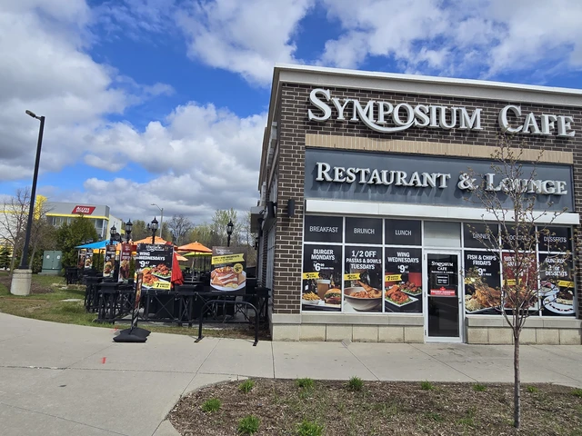 Ajax Restaurants exterior and patio outdoor dining at SYMPOSIUM CAFE RESTAURANT AJAX, a Top Family-Friendly Restaurant in Ajax, Ontario and considered one of the Best All Around Restaurants in Ajax, serving Gourmet Comfort Food and drinks in a cozy, stylish place and patio dining on the Largest and Most Comfortable Patio in the area.
