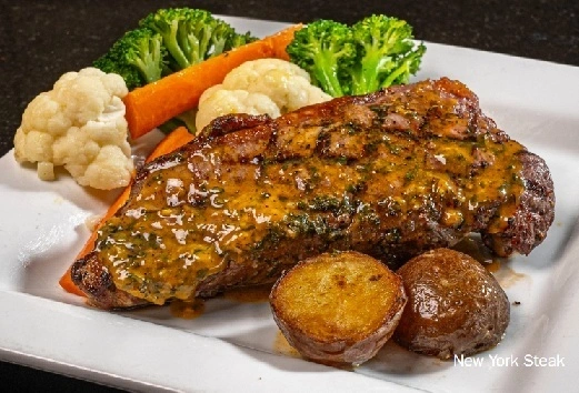 Juicy Steak dinner with vegetables and home cooked potatoes at Symposium Cafe Restaurant Ancaster, a family restaurant serving up gourmet comfort food for lunch, dinner and late night dining. 