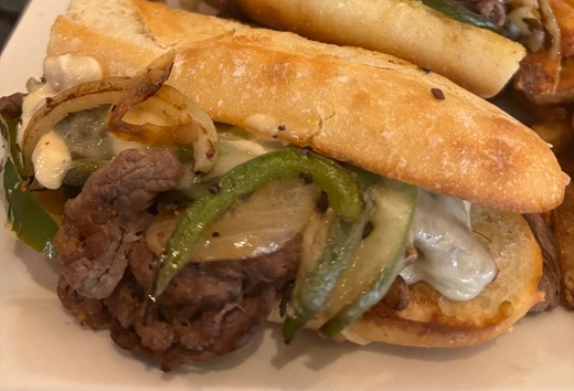 Philly Cheese Steak Sandwich one or the Signature Menu items at Symposium Cafe Restaurant Ancaster, a family restaurant serving up gourmet comfort food for lunch, dinner and late night dining.