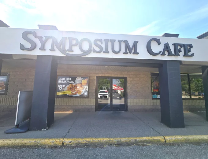 Cozy patio and exterior at Symposium Cafe Restaurant Guelph, a quaint neighbourhood restaurant across from Stone Road Mall with a comfortable outdoor dining atmosphere.