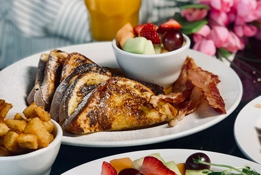 French Toast with bacon and a fruit cup at Symposium Cafe Restaurant Milton, a family restaurant serving up gourmet comfort food for weekend brunch