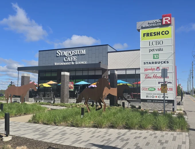 Symposium Cafe Restaurant Oshawa family restaurant exterior facade and outdoor patio seating located on Simcoe Street North, at the RioCan Windfield’s across Costco and nearby Ontario Tech University and Durham College