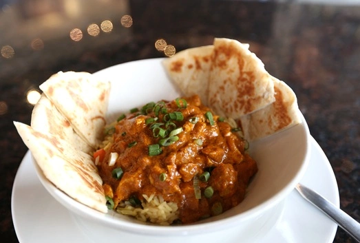 Butter Chicken Rice Bowl with pita for dipping at Symposium Restaurant Thornhill