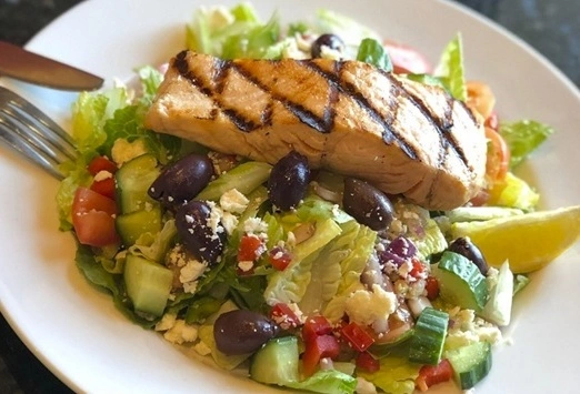 Grilled Salmon on mediterranean salad at Symposium Cafe Restaurant Woodbridge, a family restaurant serving up gourmet comfort food for lunch, dinner and late night dining.